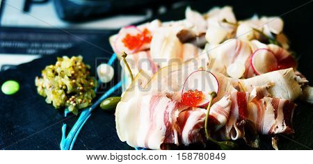 Snack of sliced bacon on a dark background