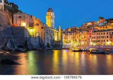 Night fishing village Vernazza with Santa Margherita di Antiochia Church, Five lands, Cinque Terre National Park, Liguria, Italy.