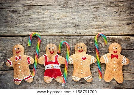Christmas homemade gingerbread cookies decorated colored icing with candy cane over wooden table