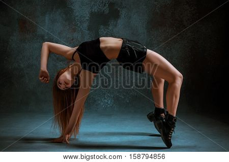 Attractive girl dancing twerk iat the blue studio background