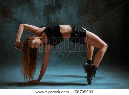 Attractive girl dancing twerk iat the blue studio background
