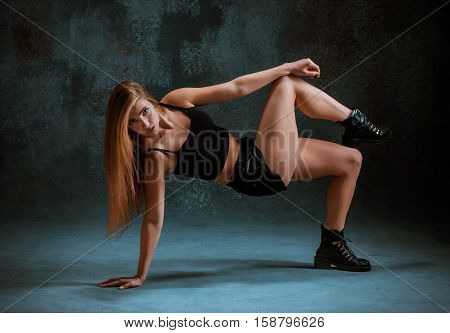 Attractive girl dancing twerk iat the blue studio background