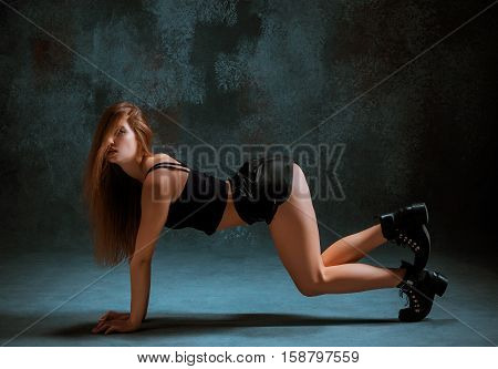 Attractive girl dancing twerk iat the blue studio background