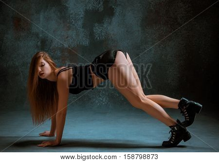 Attractive girl dancing twerk iat the blue studio background