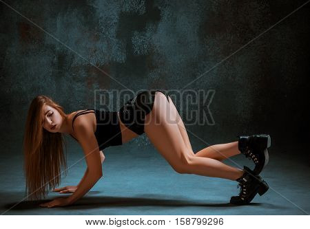 Attractive girl dancing twerk iat the blue studio background