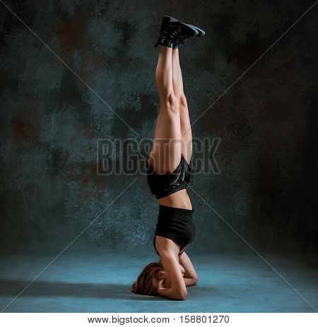 Attractive girl dancing twerk iat the blue studio background