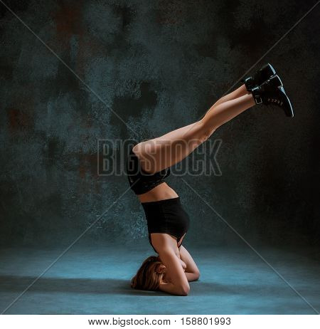 Attractive girl dancing twerk at the blue studio background