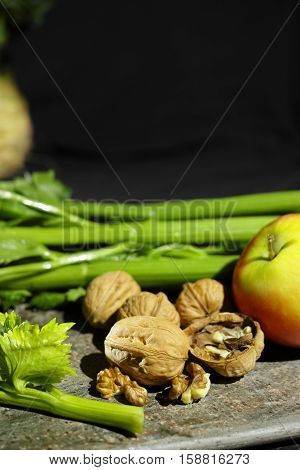 Ingredients for Waldorf salad - celery apples walnuts - fresh and healthy vegetables on granite board.