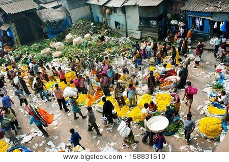 KOLKATA, INDIA - Feb 11, 2013: View of Mullik Ghat Flower Market with people scurrying around on February 11, 2013. The market is more than 125 years old. More than 2000 sellers work in the market every day
