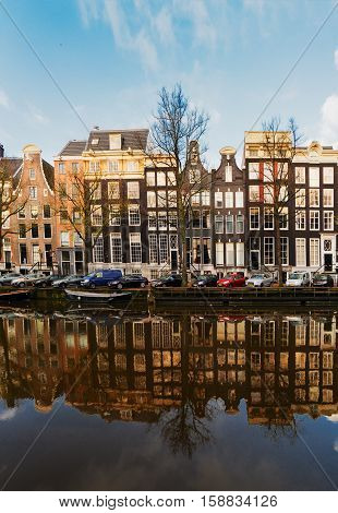 Facades of old dutch houses over canal with mirror reflections, Amstardam, Netherlands
