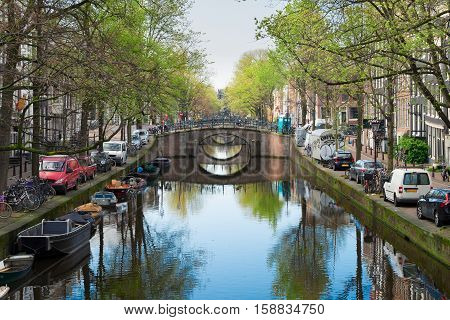 row of bridges over canal with mirror reflections in water, Amstardam, Netherlands