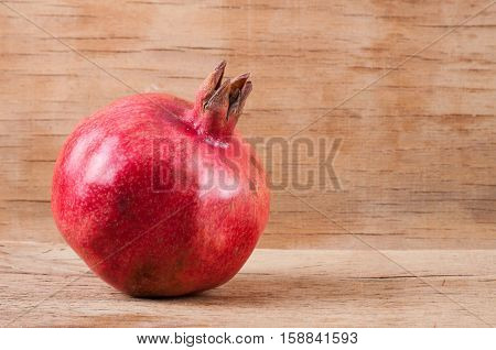 Photo ripe fresh pomegranate on wood desk. Food ingredient. Fruit