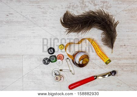 Accessories for sewing workshop on vintage wooden backgroundtop view.