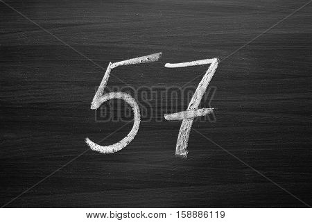number fifty seven enumeration written with a chalk on the blackboard