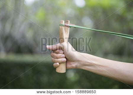 Hand pulling slingshot preparing to shoot a goal business concept