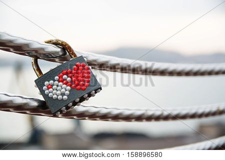Wedding lock decorated by hearts hanging on a handrail. Symbol of marriage.