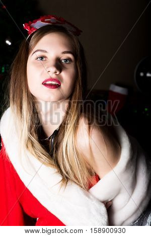 beautiful female nurse sexy woman in carnival costume, on her shoulders a red fur coat.