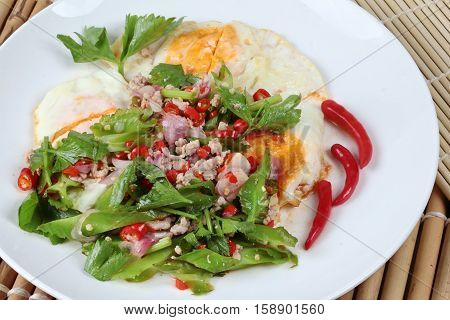 Spicy wing bean with minced pork topped fried egg as Yum Khai Doa in Thai