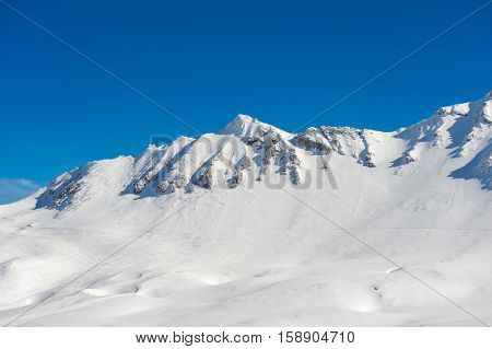 Alpine winter mountain landscape. French Alps covered with snow in sunny day. Val-d'Isere, France