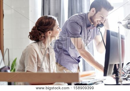 business, startup and people concept - happy creative team calling on phone in office