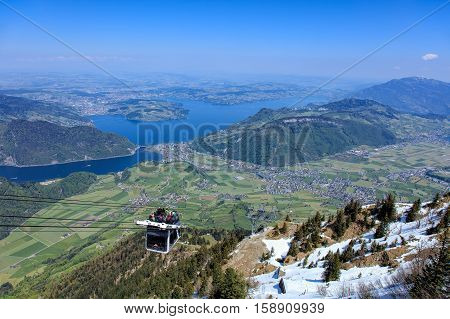 Mt. Stanserhorn, Switzerland - 7 May, 2016: people in a gondola of the Stanserhorn Cabrio cable car. Stanserhorn Cabrio is the the world's first double deck open top cable car, it carries 60 passengers per cabin with room for 30 on the open deck.