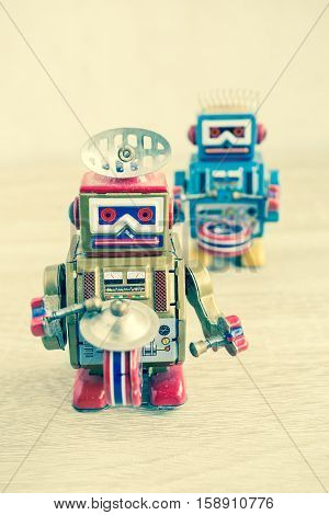 Old robot toy on wood table, vintage color style, vintage tone background.