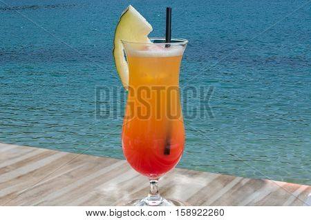 Colorful cocktail on the table of a bar in the restaurant in the background the blue sea.