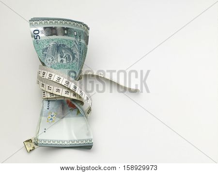 stack of malaysia ringgit tight with measuring tape
