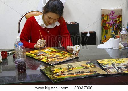 HANOI VIETNAM October 30 2016 : Unidentified artist paints in a workshop of lacquer of Hanoi. Lacquerware are objects decoratively covered with lacquer mostly from East Asian cultures.