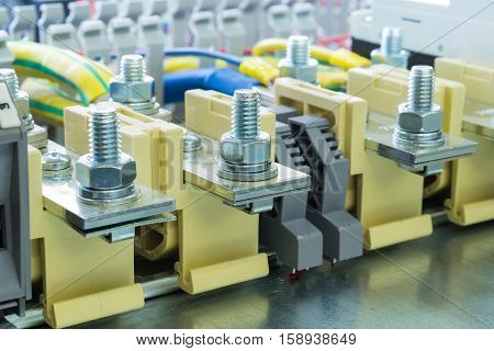 beige bolt bushing terminals on the DIN rail located on the mounting panel is connected to them wires fixed retainers