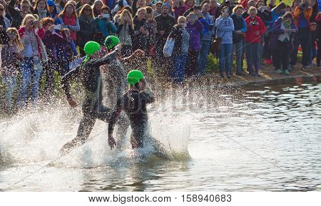 GRAFHAM, CAMBRIDGESHIRE, ENGLAND - MAY 22, 2016:  Triathlon swimmers entering open water swim stage.