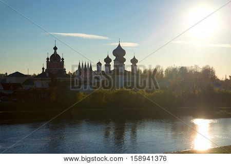 View of the old Tikhvin Deiparous Uspensky monastery from the river Tikhvinki at sunset. Tikhvin, Russia