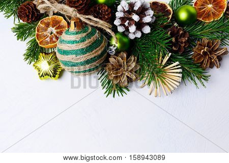Christmas background with rustic ornaments and snowy decorated pinecone. Christmas background with fir branches. Copy space.