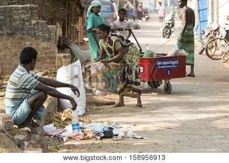 Illustrative image. Pondicherry, Tamil Nadu, India - March 03, 2014. Household waste pastic pick up in the village. Women workers Plastic bottles, papers, bin