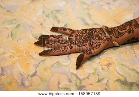 hena floral decoration on ladies hand with bangle