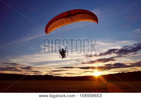 Paragliding extreme sport during sunset in landscape