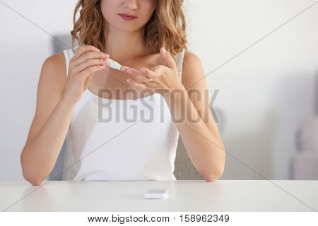 Woman using lancelet on finger