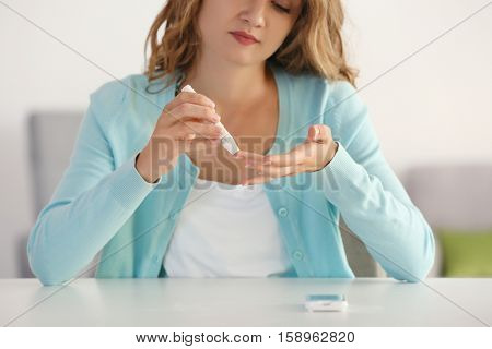 Woman using lancelet on finger