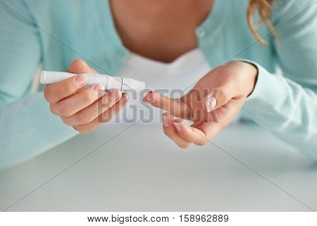 Woman using lancelet on finger