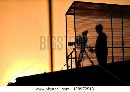 Cameraman's silhouette broadcasting live from a stadium