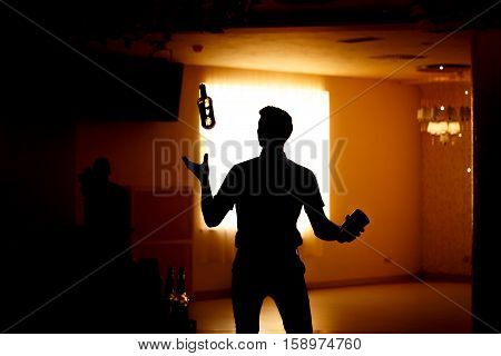 Barman show. Bartender pours alcoholic cocktails. Black silhouette
