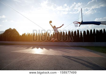 Young Man Jumping And Making A Fantastic Slam Dunk Playing Stree