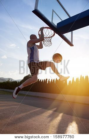 Young Man Jumping And Making A Fantastic Slam Dunk Playing Stree
