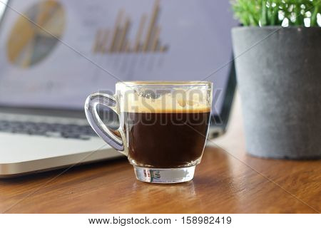 Laptop and coffee cup on old wooden table