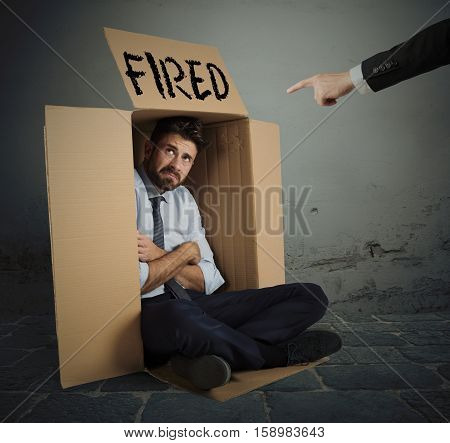 Desperate and fired businessman hides in the cardboard