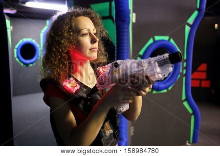 MOSCOW - DEC 13, 2014: Woman with curly hair (with model release) in a special vest with a laser-automat in laser tag at the shopping center Capitol Vernadsky