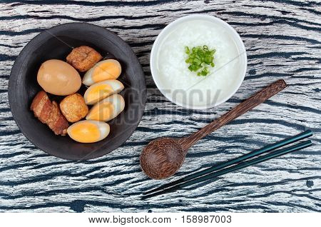 Rice gruel and stewed boiled egg with tofu and streaky pork served .