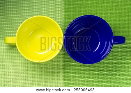 Green Kitchen Backdrop With Empty Yellow And Blue Cup.