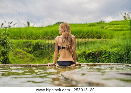 Young Woman Tourist In Belulang Hot Springs In Bali On The Background Of Rice Terraces