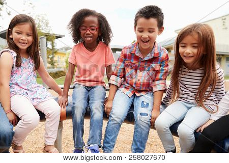 Kids sitting on a spinning carousel in their schoolyard